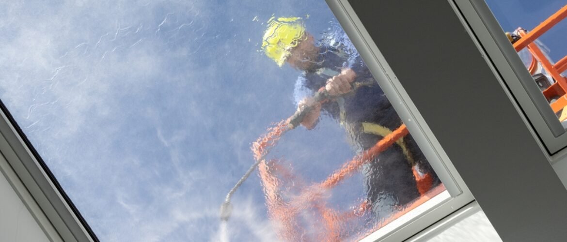 Worker,On,A,Cherry,Picker,Cleaning,A,Roof,Windows,With